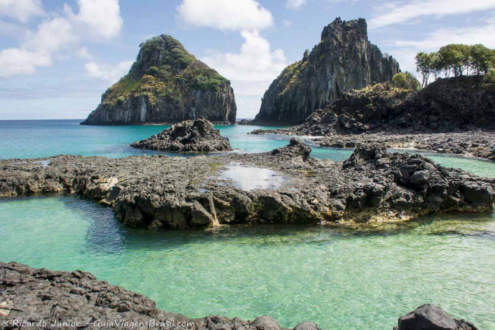 Imagem do morro e pedras na Praia Baía dos Porcos em Fernando de Noronha.